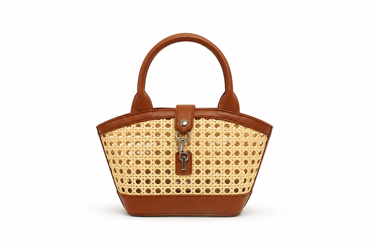 Structured mini tote bag with open-weave rattan body, leather-look arched handles and trim, front tab turn-lock closure, and