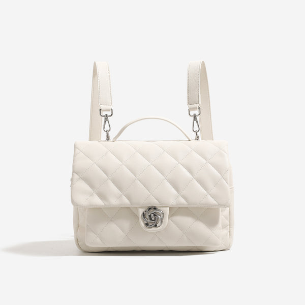 Diamond-quilted flap backpack handbag with silver-tone flower turn-lock, top handle, and dual shoulder straps, detail view 7