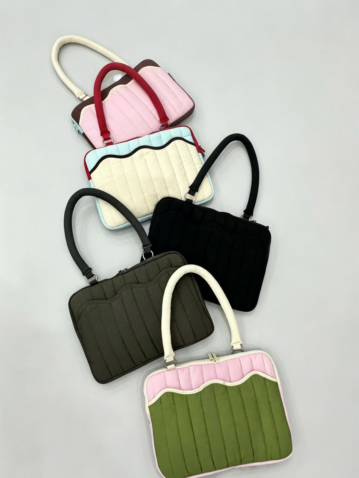 Quilted colorblock handbag with wavy scalloped front panel, padded arched top handles, and dual zip closure, detail view 12