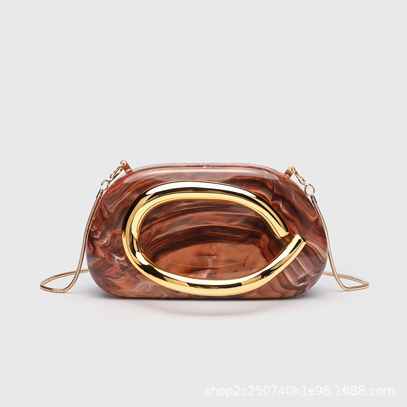 Kleine rechteckige Crossbody-Clutch mit abgerundeten Ecken, oversized poliertem C-förmigem Goldgriff und schmalem Goldkettenriemen, Detailansicht