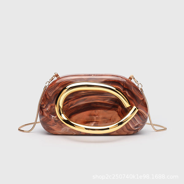 Kleine rechteckige Crossbody-Clutch mit abgerundeten Ecken, oversized poliertem C-förmigem Goldgriff und schmalem Goldkettenriemen, Detailansicht