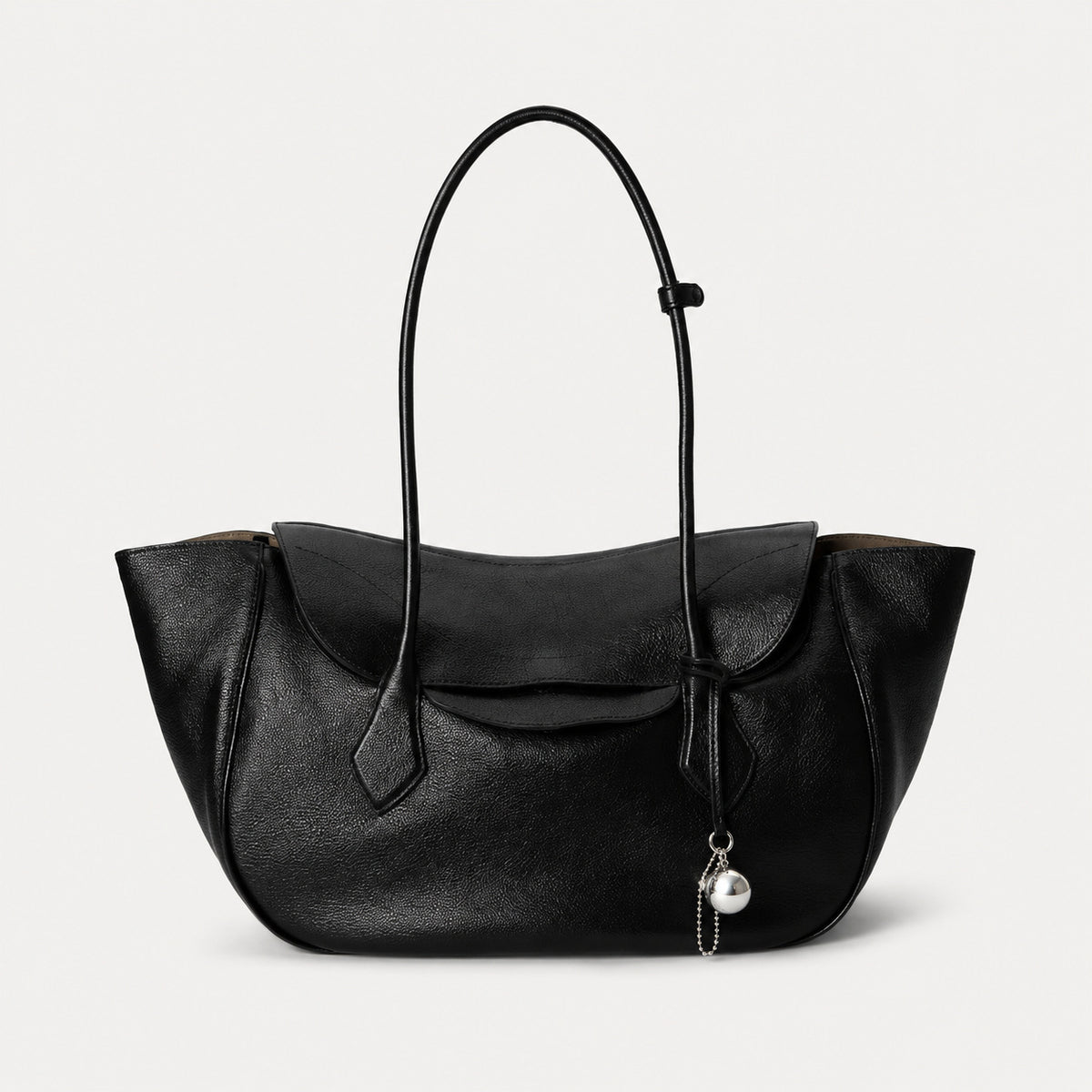 Large winged leather-look tote bag with single arched handle, stitched flap-front panel, and silver ball charm in cognac