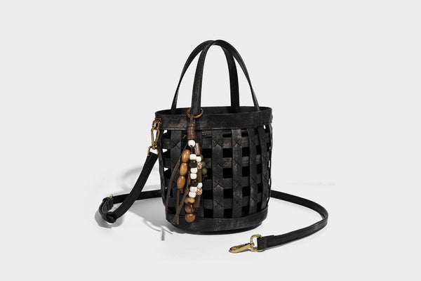 Small woven lattice bucket bag in brown leather-look finish with beaded tassel charm, dual top handles, and detachable