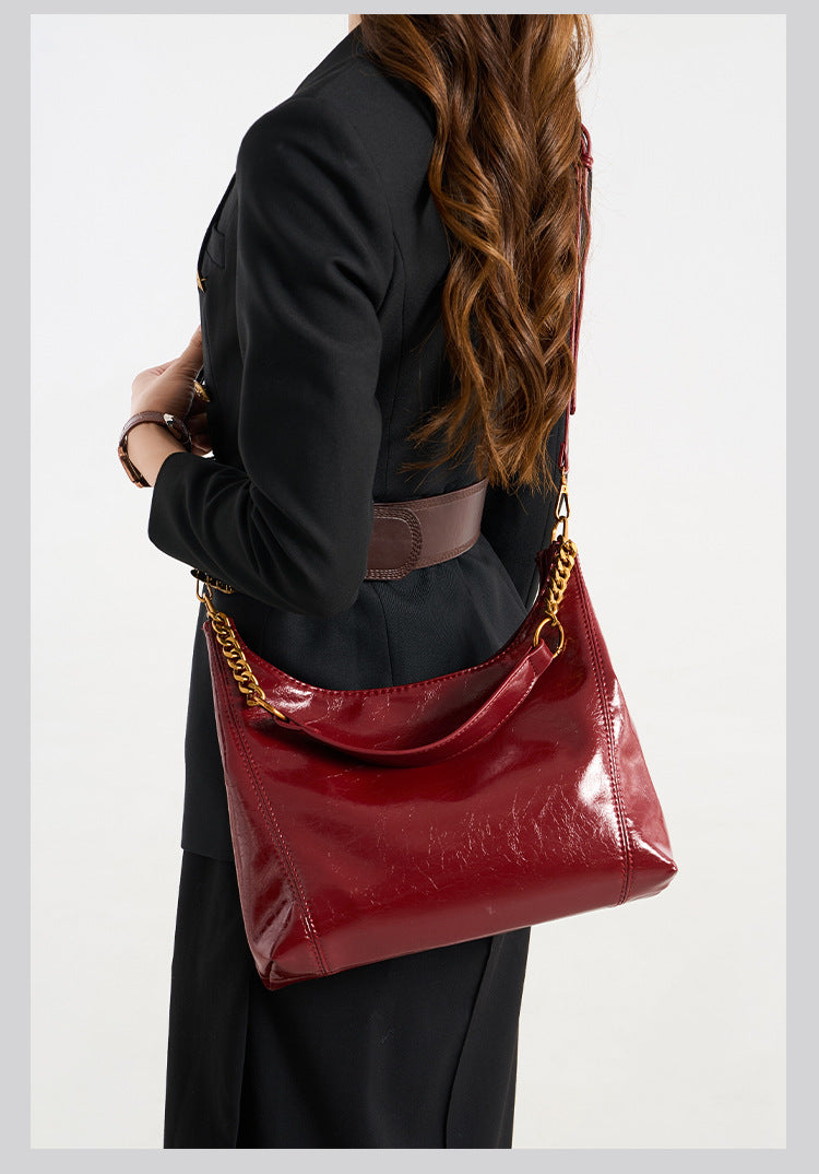 Glossy leather-look hobo shoulder bag with gold-tone chain-and-leather strap in deep burgundy red, detail view 8