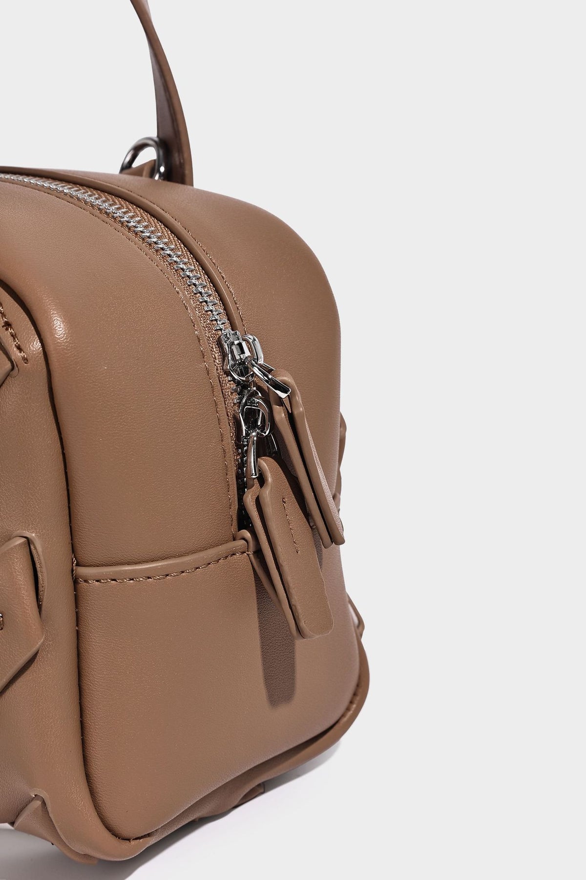 Small structured satchel bag with two-tone woven front panel, dual top handles, and detachable crossbody strap in tan brown