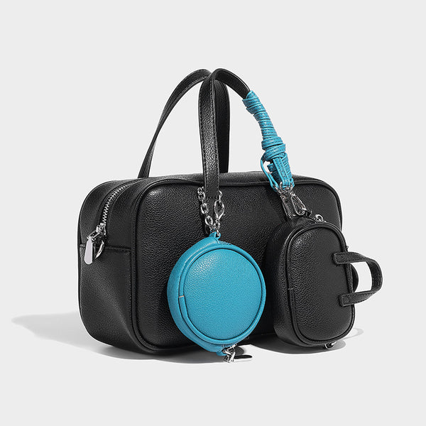 Structured pebbled leather-look Boston bowling bag in tan with blue detachable round mini pouch, dual top handles, and