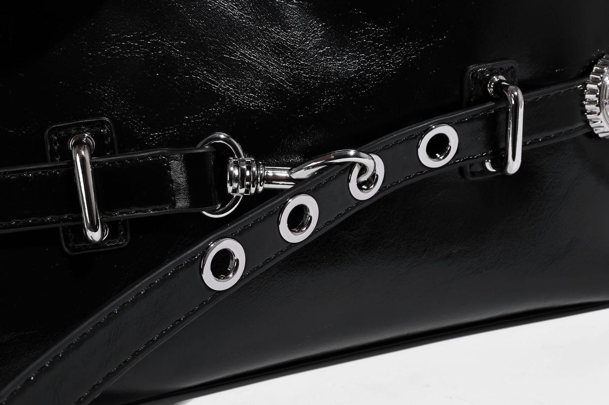 Glossy black slouchy hobo shoulder bag with silver-tone hardware, belt-style grommet strap at base, and long adjustable