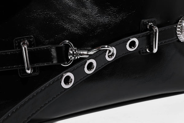Glossy black slouchy hobo shoulder bag with silver-tone hardware, belt-style grommet strap at base, and long adjustable