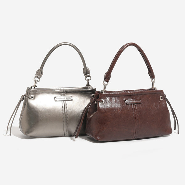 Small retro convertible shoulder bag with glossy leather-look finish, side drawstring ties, top zip closure, and silver-tone