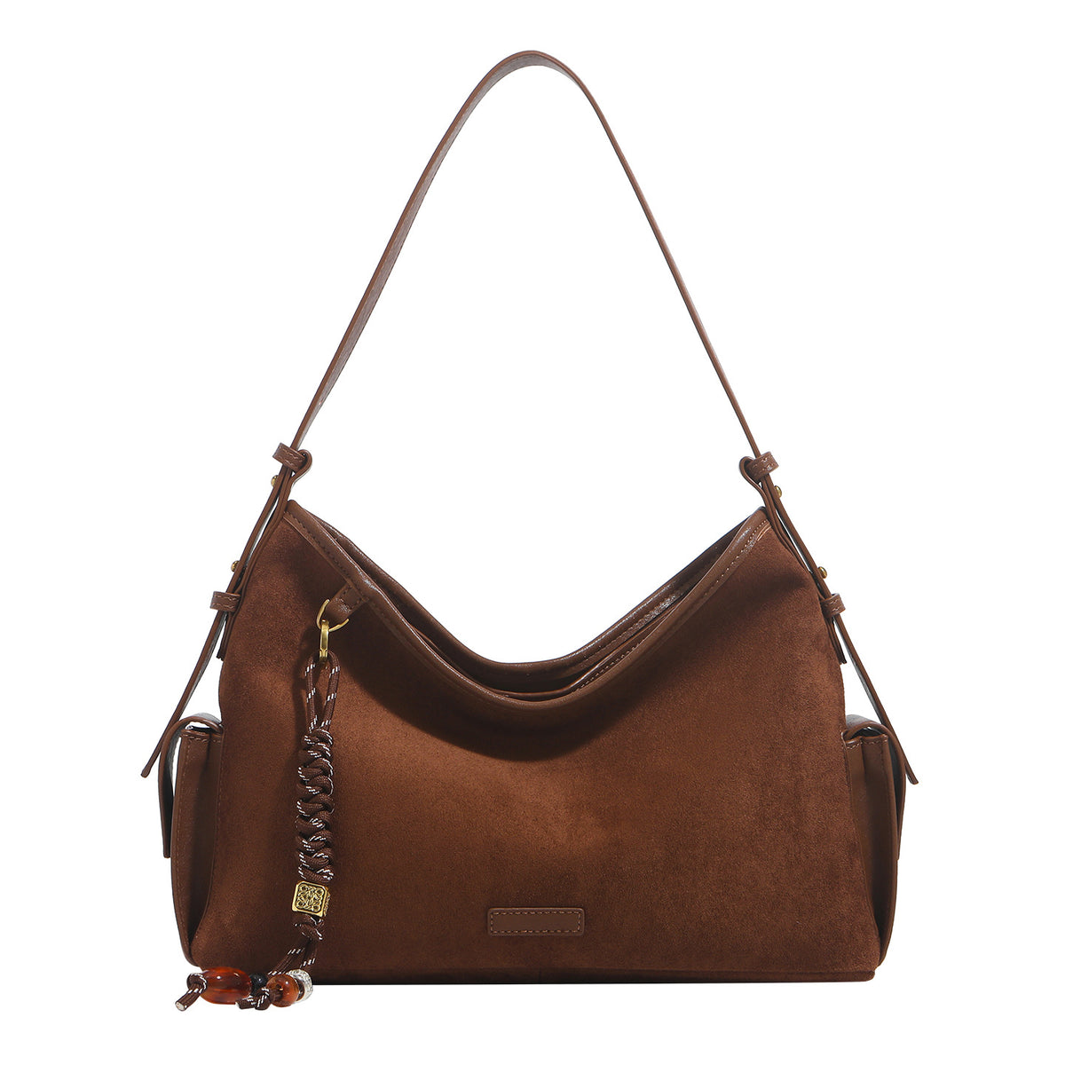 Caramel brown slouchy hobo shoulder bag with matte suede-like finish, braided tassel charm, brass-tone hardware, and, detail