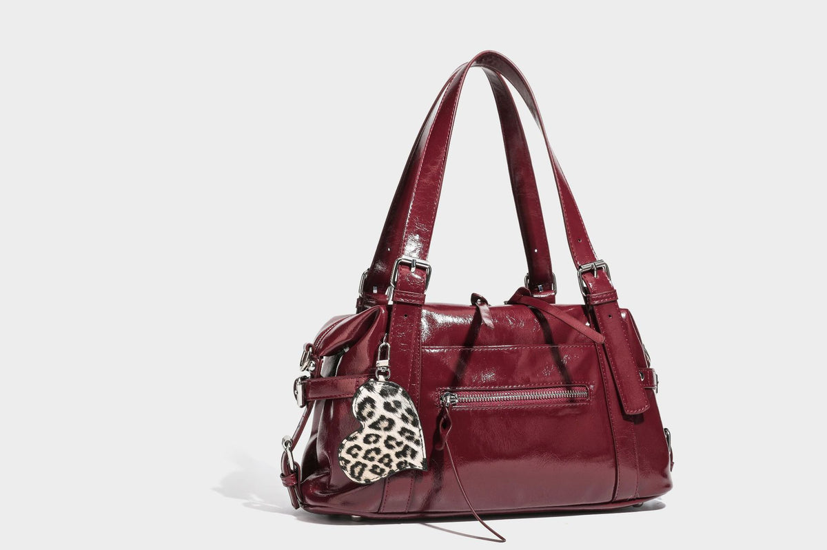 Strukturierte Schultertasche in glänzender Lederoptik mit abgerundetem Korpus, silberfarbenen Beschlägen, Reißverschlussfach auf der Vorderseite und Leopardenmuster