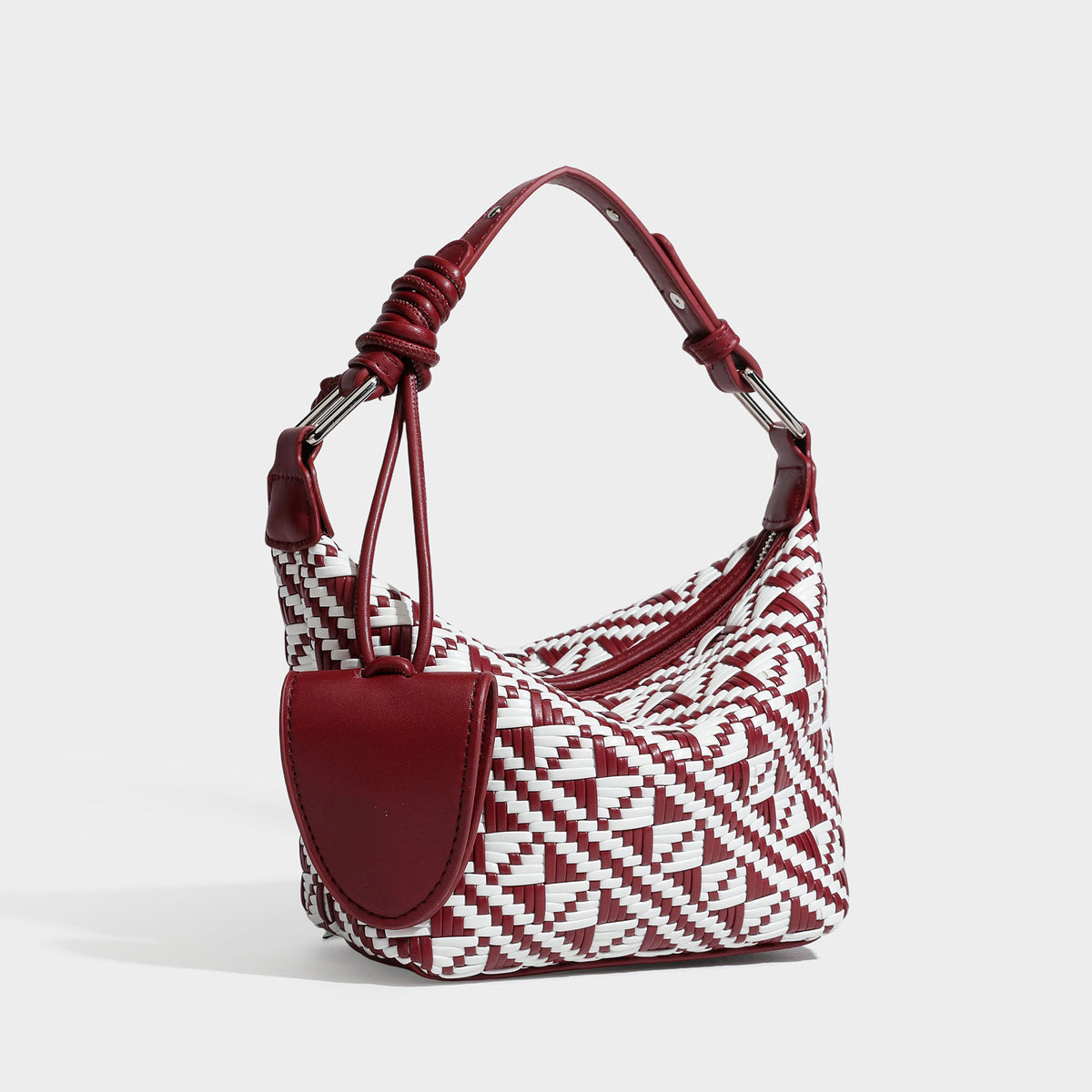 Kleine gewebte Schultertasche mit geometrischem Schwarz-Weiß-Muster, glatten dunkelbraunen Details in Lederoptik, geknotetem verstellbarem Riemen, Seitenansicht