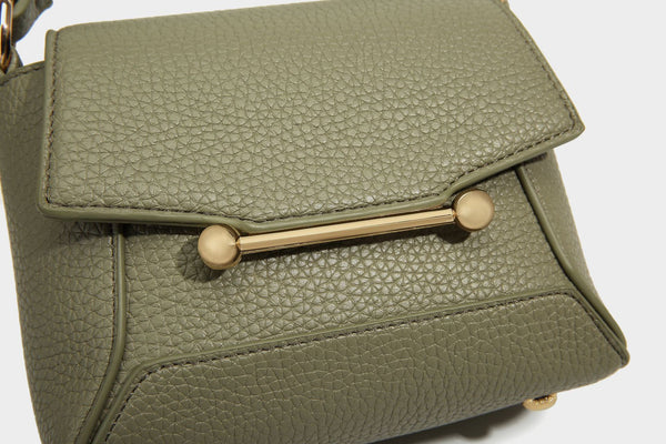 Small structured pebbled flap mini satchel with gold-tone bar hardware, short top handle, and detachable crossbody strap