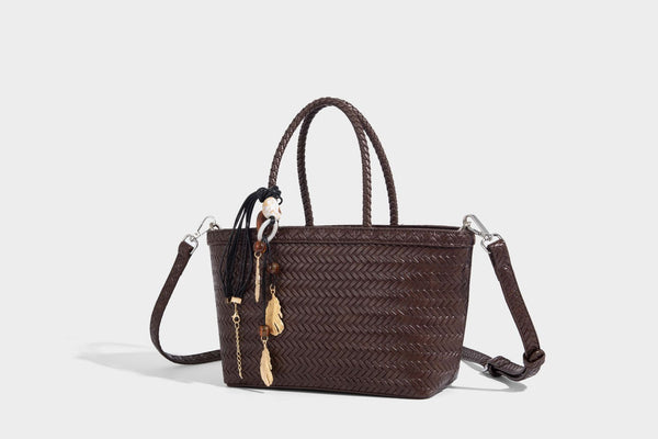 Structured chevron woven leather-look tote bag with braided top handles, gold feather charm, and adjustable shoulder strap