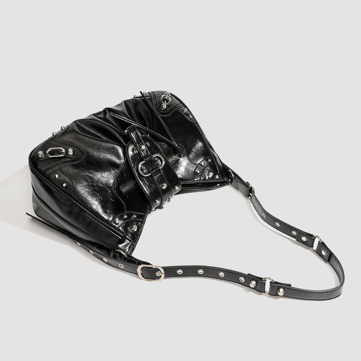 Black glossy studded hobo shoulder bag with silver rivet hardware, front buckle accent, and adjustable strap, detail view 4