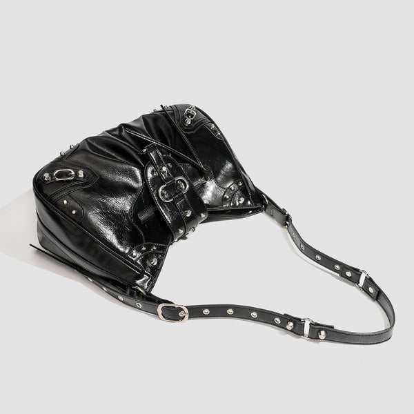 Black glossy studded hobo shoulder bag with silver rivet hardware, front buckle accent, and adjustable strap, detail view 4