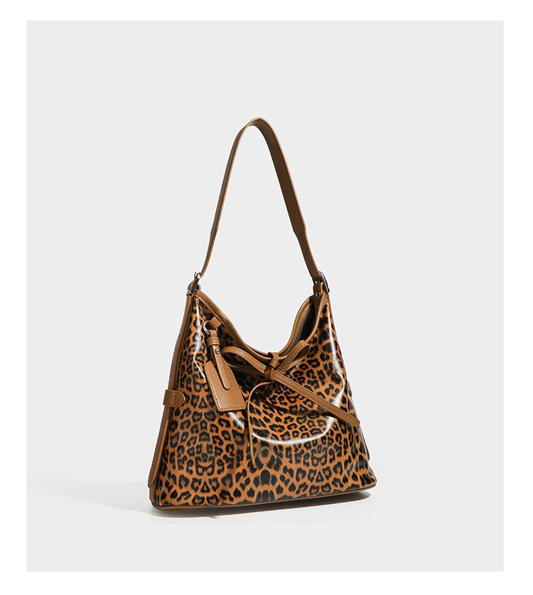 Slouchy leopard print shoulder hobo bag with black leather-look trim, tie-top closure, and single long strap, detail view 17