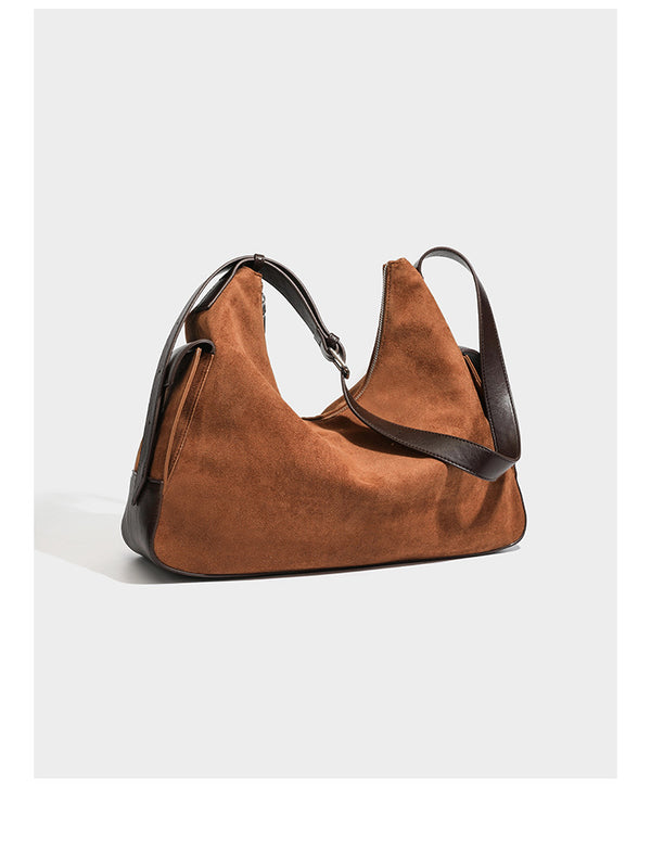 Cognac brown suede-look slouchy shoulder bag with dark brown leather-look trim, top zip closure, exterior side pocket, and