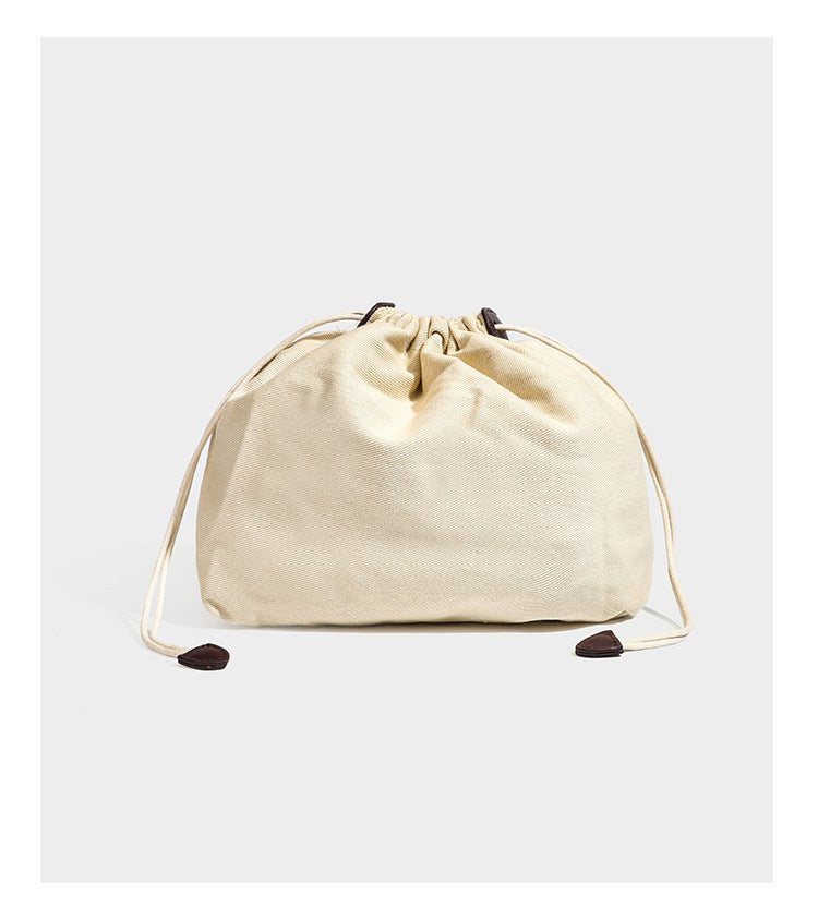 Strukturierte Henkeltasche aus geflochtenem Material in Dunkelbraun mit geflochtenen Henkeln, seitlichen Zugbändern und befestigtem Mini-Täschchen aus geflochtenem Material mit