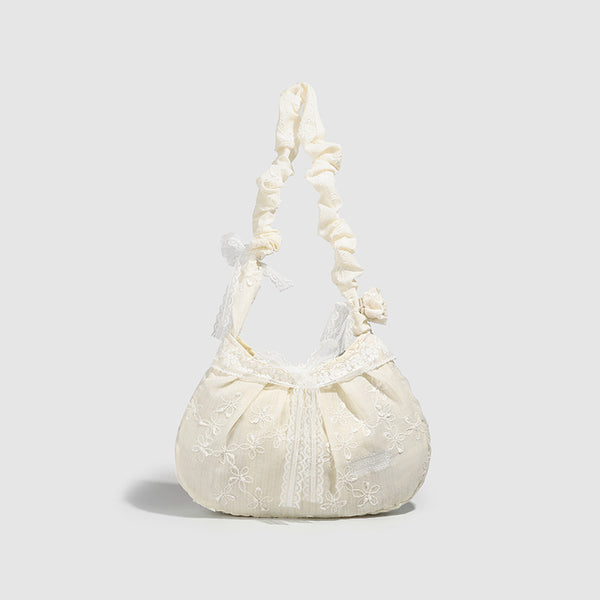 Elfenbeinfarbene, halbmondförmige Schultertasche mit Blumenstickerei, Spitzenbesatz und gerafftem Rüschenstoffriemen mit Schleifendetail, Vorderansicht