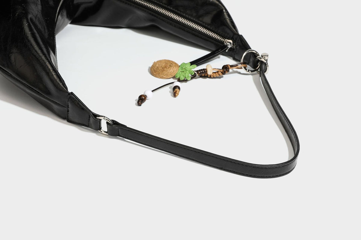 Legere, halbmondförmige Hobo-Schultertasche in glänzender, geknautschter Lederoptik mit schmalem Riemen, Ringbeschlägen in Silberoptik und