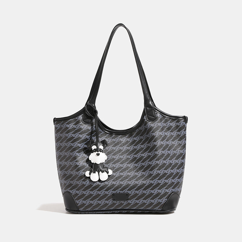 Large black monogram tote bag with tonal grey repeat print, leather-look trim, and black-and-white schnauzer bag charm