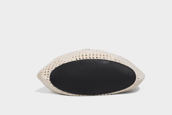 Cream openwork crochet hobo bag with black leather-look strap and trim patch accent, slouchy teardrop silhouette, detail view