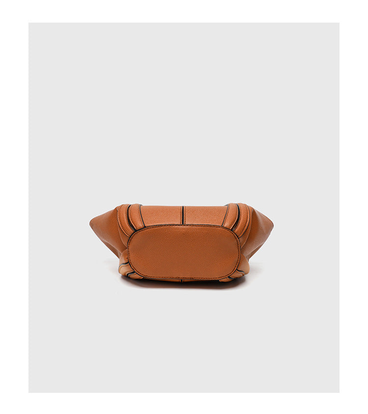 Structured open-top tote bag in tan brown pebbled leather-look finish with vertical seam accents, black edge piping, curved