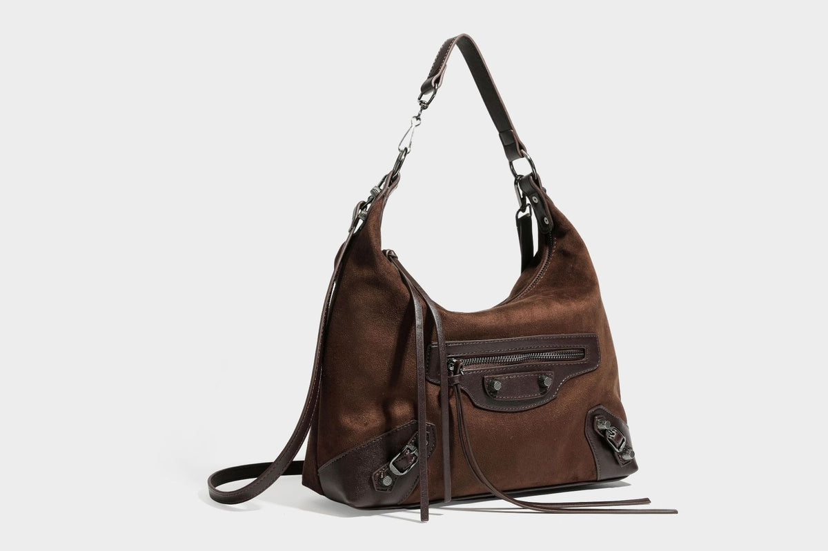 Slouchy suede-finish hobo shoulder bag with dark hardware, exterior zip pocket, tassel ties, and detachable crossbody strap