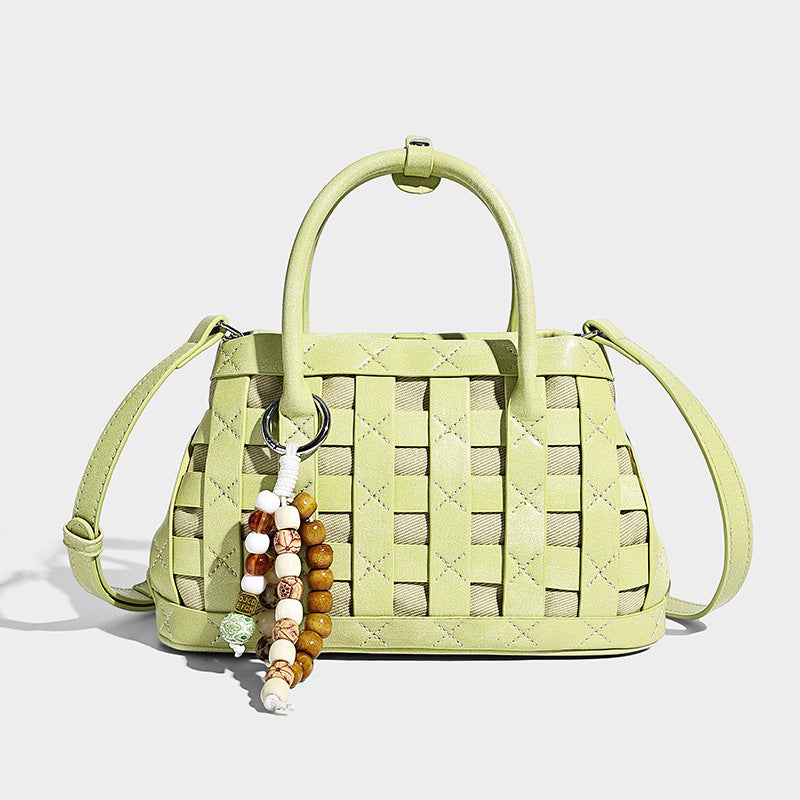 Small structured woven satchel tote with rounded top handles, silver-tone ring hardware, and bead tassel charm, detail view 4