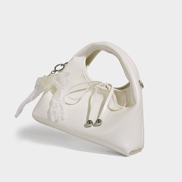 Kleine glänzende kuppelförmige Henkeltasche in Lederoptik mit Zugbandverschluss, weißem Spitzen-Schleifenanhänger und silberfarbenen Beschlägen
