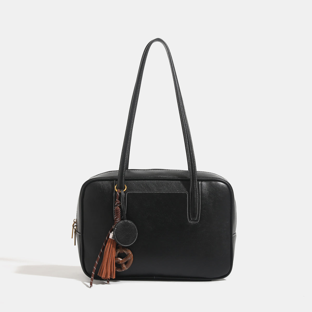 Structured rectangular leather-look shoulder bag with top zip, tassel and resin ring charm, and contrast topstitching, detail