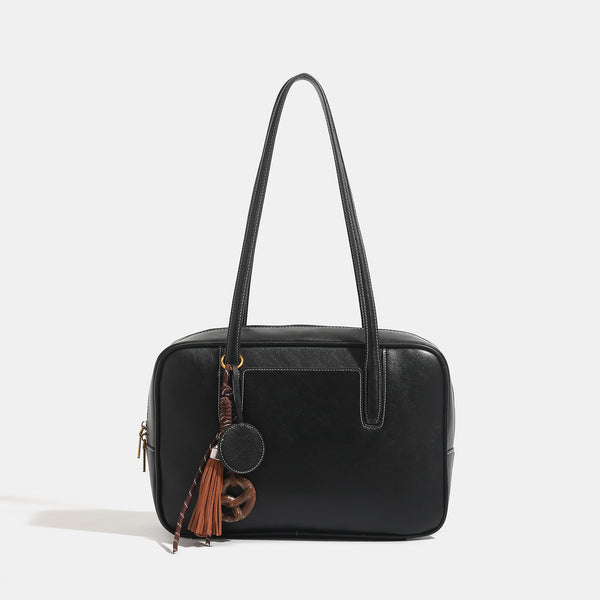 Structured rectangular leather-look shoulder bag with top zip, tassel and resin ring charm, and contrast topstitching, detail