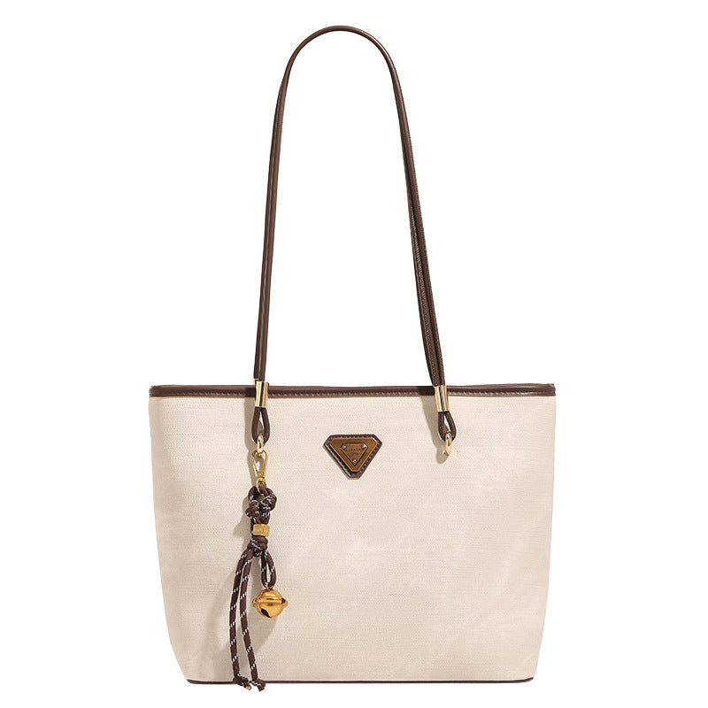 Großer strukturierter Shopper mit offenem Oberteil in Creme mit dunkelbraunen Besätzen in Lederoptik, zwei Schulterriemen und dreieckigem Logo-Badge