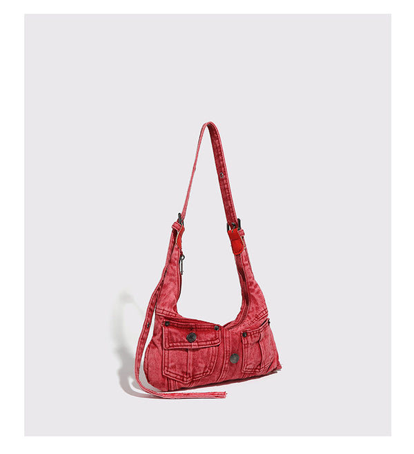 Compact washed red distressed-textile shoulder bag with front flap pockets, dark metal hardware, and long adjustable strap