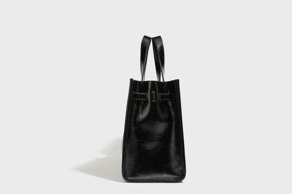 Strukturierte, glänzende Tote-Bag in Lederoptik mit silberfarbenem Drehverschluss, zwei Tragegriffen und abnehmbarem Schulterriemen, Detailansicht