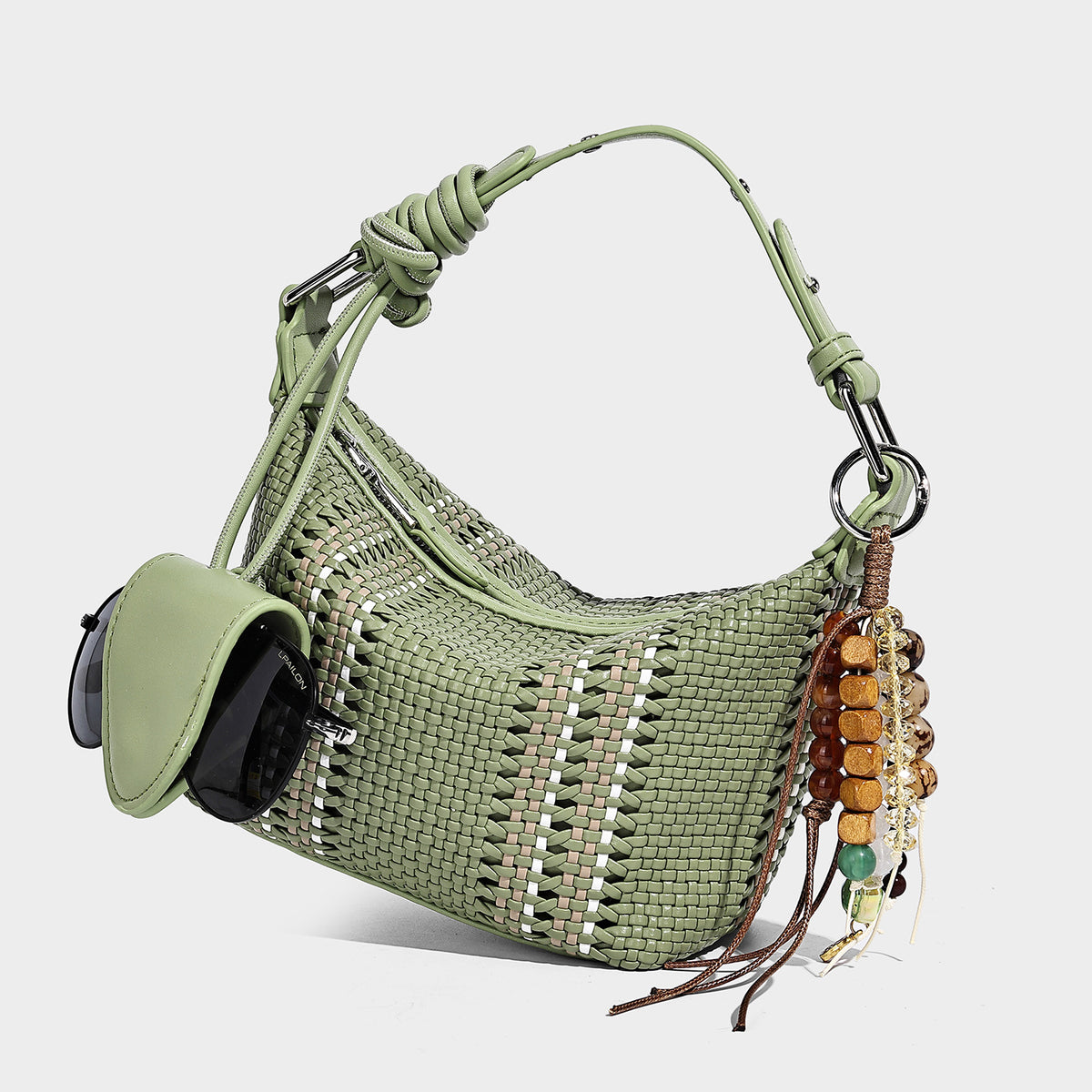 Small woven crescent shoulder bag with leather-look trim, zip closure, silver-tone ring hardware, and beaded tassel charm