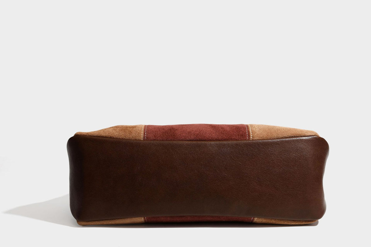Patchwork suede-look barrel shoulder bag in brown, rust, tan, beige, and gray panels with double leather-look straps and