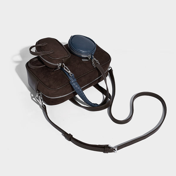 Strukturierte Boston-Bowlingtasche in Veloursleder-Optik, dunkelbraun, mit Henkeln mit blauen Akzenten und abnehmbarem Mini-Rundtäschchen, Detailaufnahme