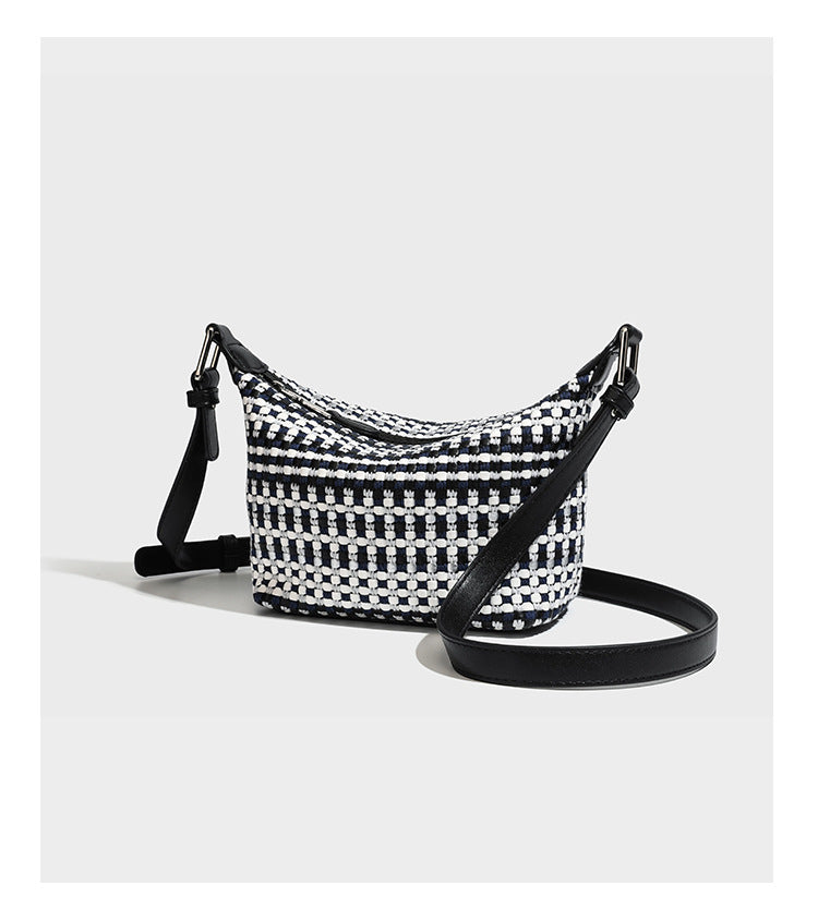Small crescent shoulder bag in black-and-white woven textile with smooth black leather-look trim, zip-top closure, knotted
