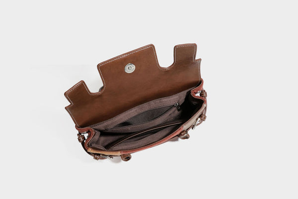 Structured color-block satchel bag in brown, rust, beige, and taupe suede-look panels with white topstitching, front buckle
