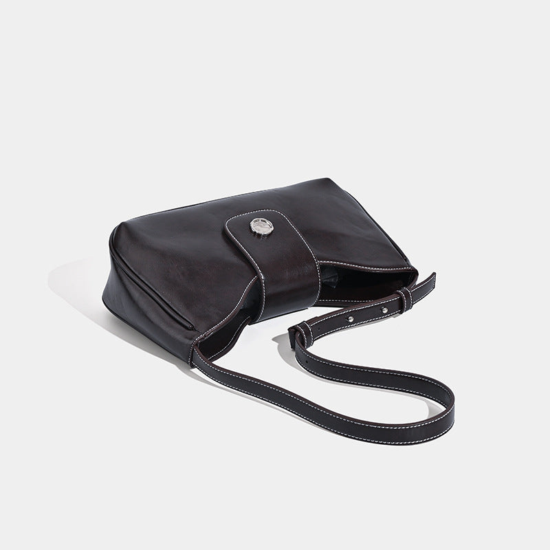 Compact glossy leather-look shoulder bag with round metal snap closure and contrast stitching, detail view 4