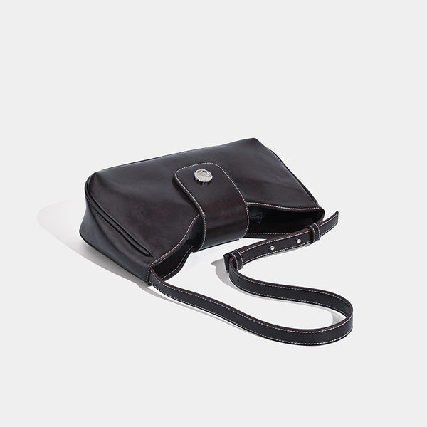 Compact glossy leather-look shoulder bag with round metal snap closure and contrast stitching, detail view 4