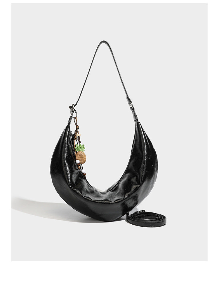 Lässig fallende Hobo-Schultertasche in Halbmondform mit glänzender, geknautschter Lederoptik, schmalem Riemen, silberfarbenen Ringbeschlägen und