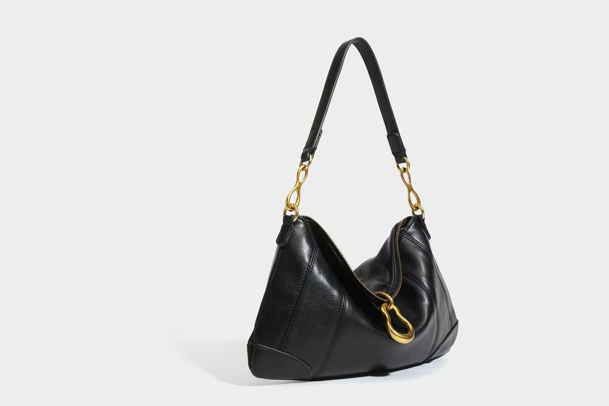 Slouchy denim shoulder bag with dark leather-look trim, gold-tone chain-link hardware, and top zipper closure, detail view 20