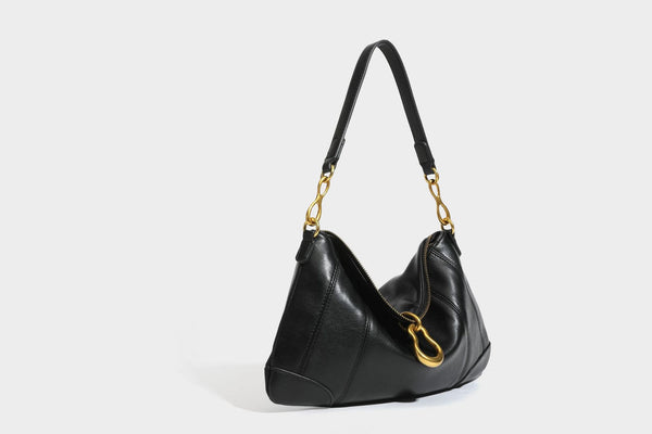 Slouchy denim shoulder bag with dark leather-look trim, gold-tone chain-link hardware, and top zipper closure, detail view 20