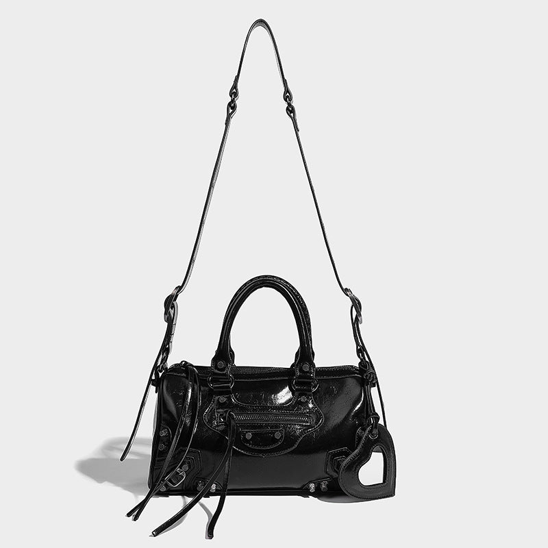 Glossy studded mini satchel bag with braided top handles, front zip pocket, heart charm, and detachable crossbody strap