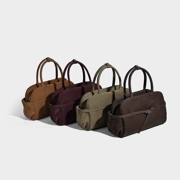 Strukturierte Henkeltasche mit matter, genarbter Oberfläche, umlaufendem Riemen mit Ringbeschlägen, zwei Tragegriffen und abnehmbarem Umhängeriemen