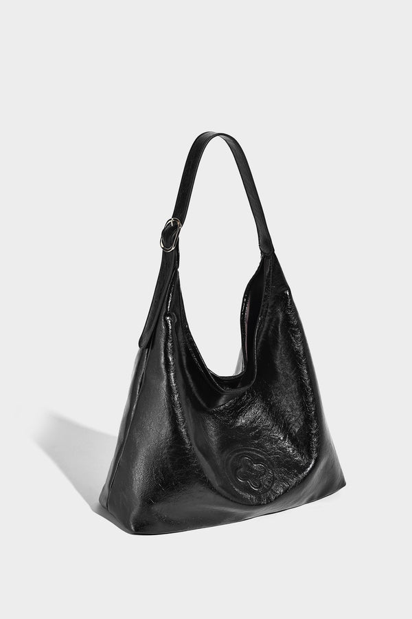 Glossy slouchy hobo shoulder bag with adjustable strap and embossed floral emblem, detail view 11