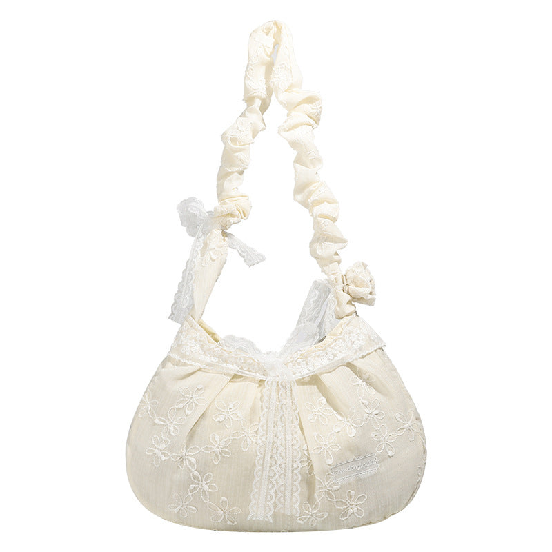 Elfenbeinfarbene, halbmondförmige Schultertasche mit Blumenstickerei, Spitzenbesatz und gerafftem Rüschenstoffriemen mit Schleifendetail, Detailansicht